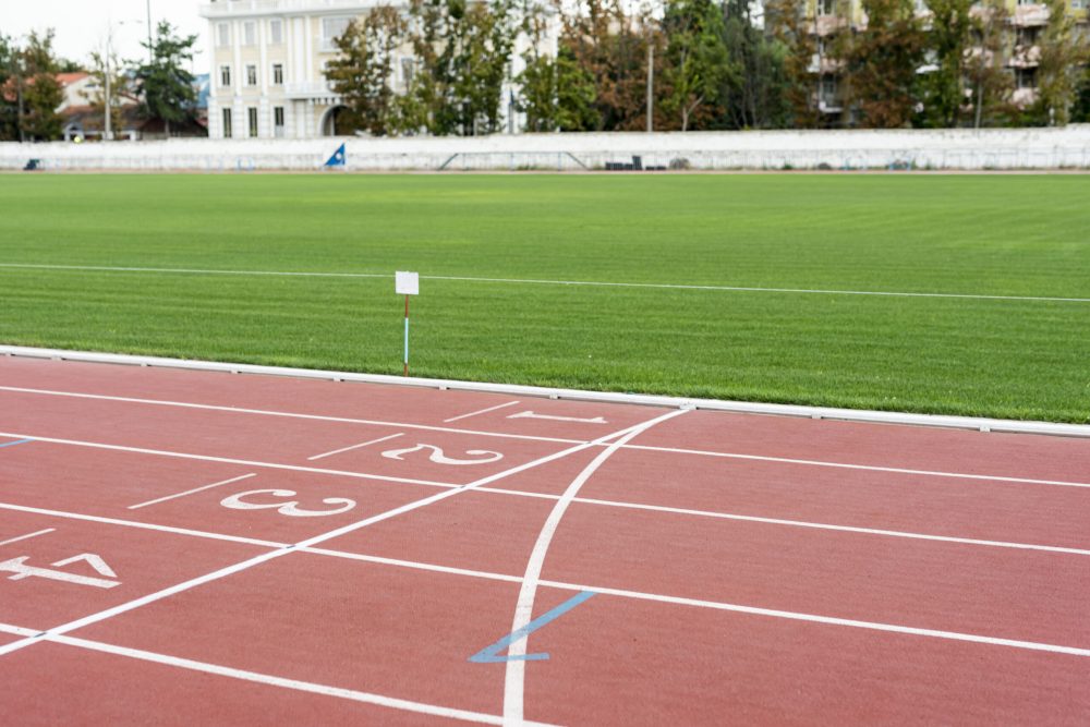 running-track-with-grass-field-sunny-day